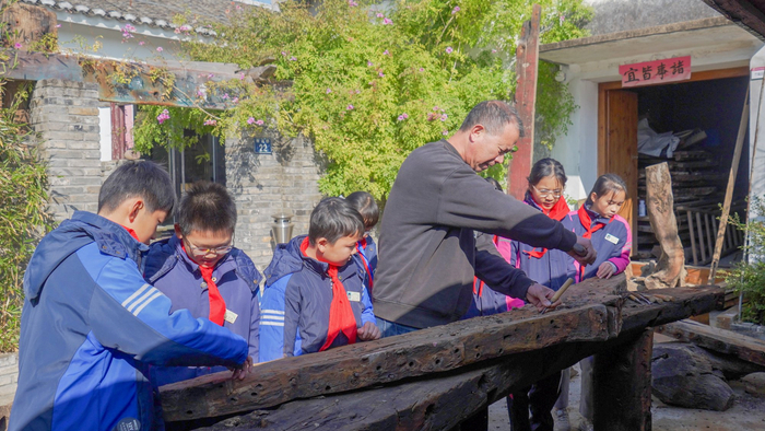 王群为学生演示渔文化作品雕刻（央广网记者 俞烨 摄）