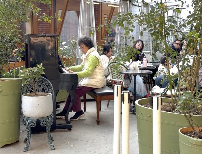 Artist La Pie法式烘焙坊店外，路人正在弹奏钢琴