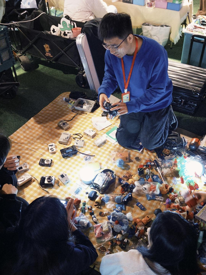 济南“鬼市”活动中，售卖二手相机的摊主在展示产品。（王鹤颖 报道）