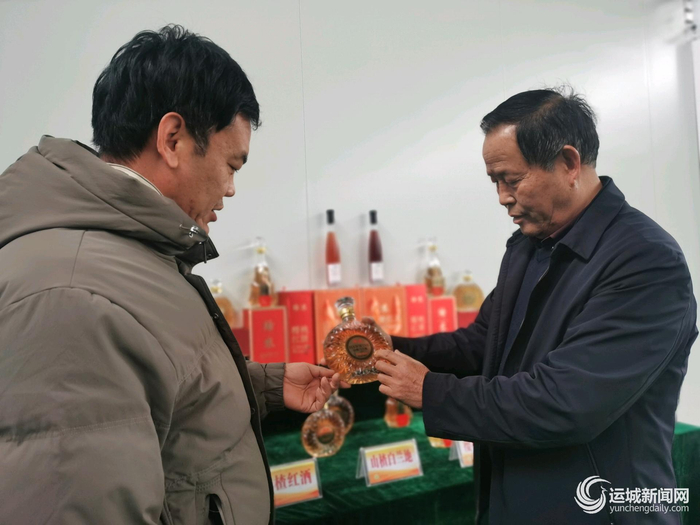 边李岗（左）和杜安全（右）交流新产品。 本报记者 景 斌 摄