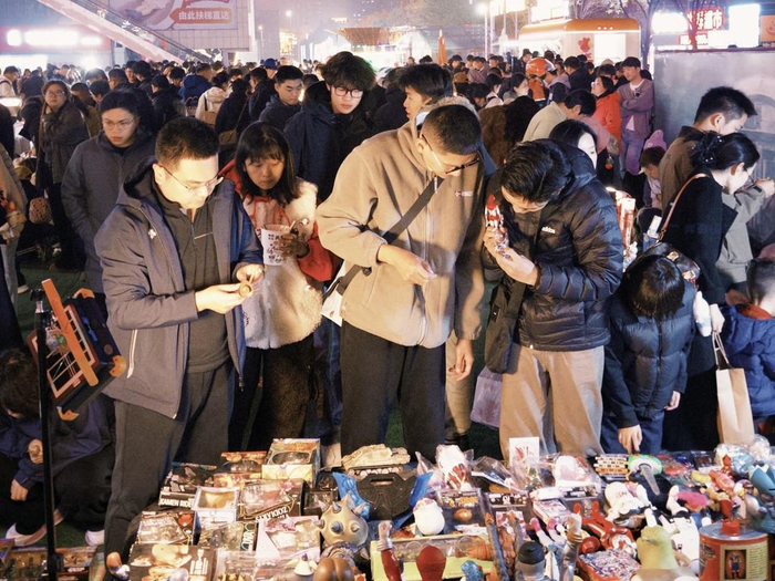 济南“鬼市”活动中，年轻消费者挑选二手玩具。（王鹤颖 报道）