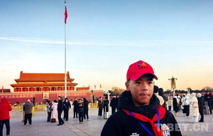 图为西藏自治区那曲市色尼区青少年足球队中场球员多杰顿桑在天安门广场与国旗合影 摄影：刘莉 