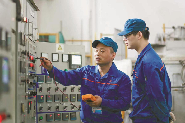 2019年，罗明浩（左）在铸造车间指导员工操作。