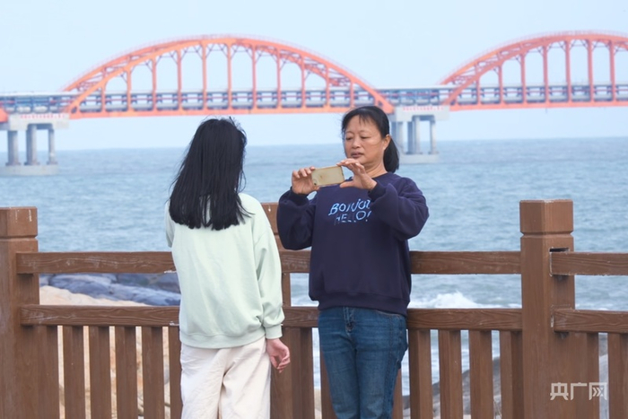 游客在石碑山角领海基点主题公园“打卡”拍照（央广网记者  官文清  摄）