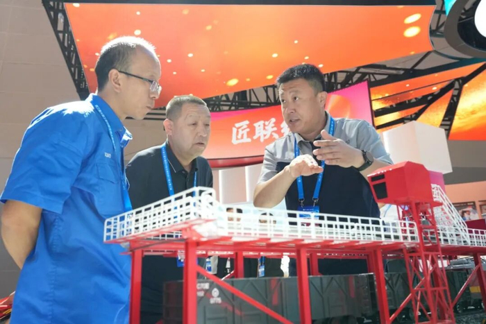 9月23日，全国劳模宋涛（右）在第三届大国工匠创新交流大会上与同行业技术人员交流