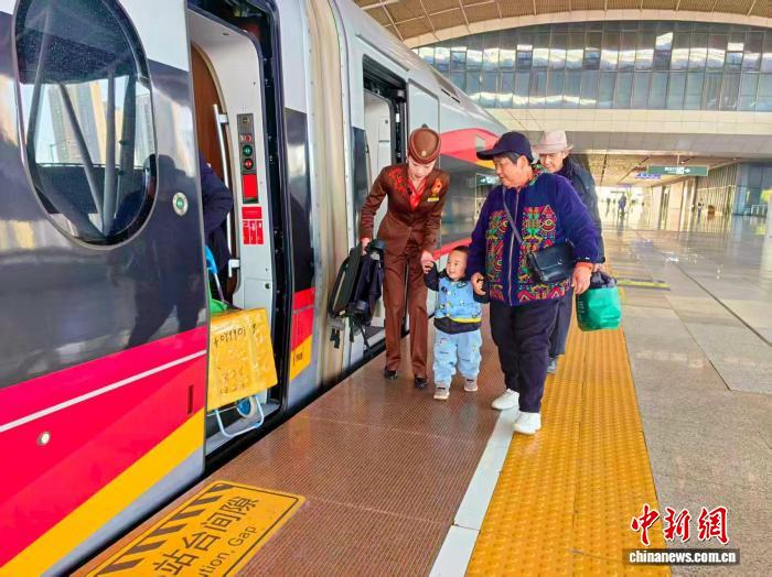图为武铁工作人员帮助旅客乘车。　武铁供图