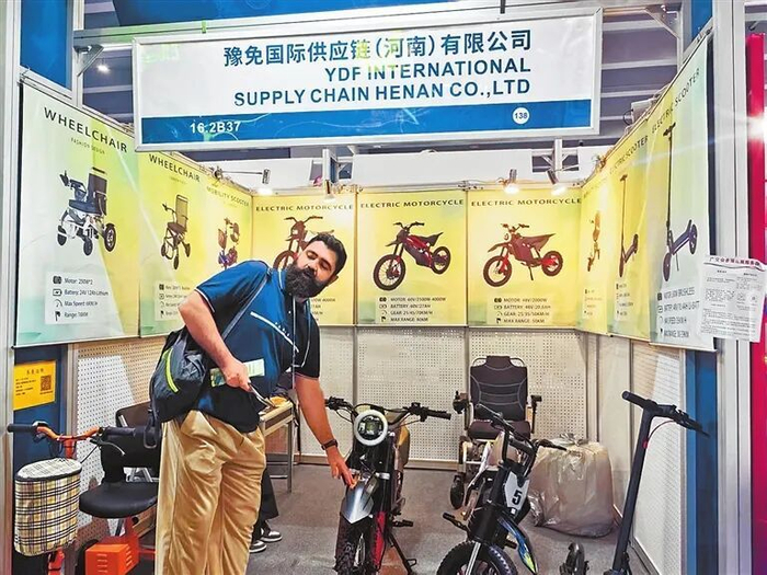 广交会上，东欧客商询问电动车的续航性能。郭俏丽 摄