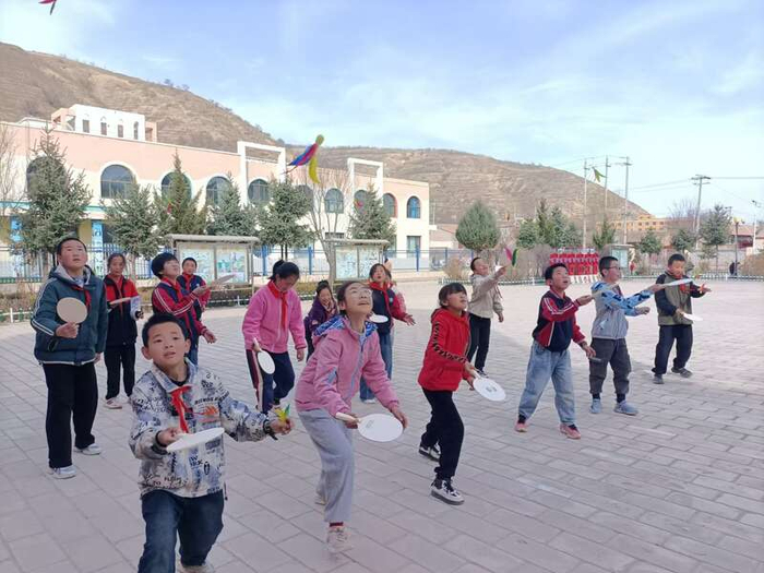 　　会宁县翟家所镇中心小学学生在操场练习板羽球。李耀华/摄