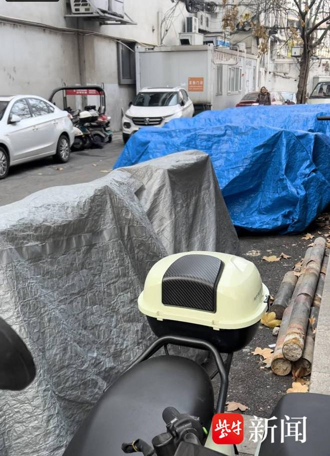 盖着防雨布的待售库存旧国标电动车。任国勇 摄