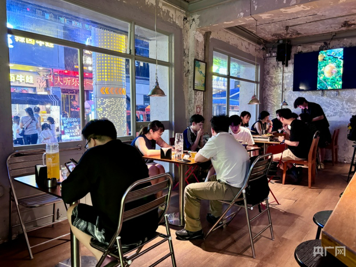 年轻顾客举杯畅饮，享受惬意时光（央广网记者  杨贇  摄）