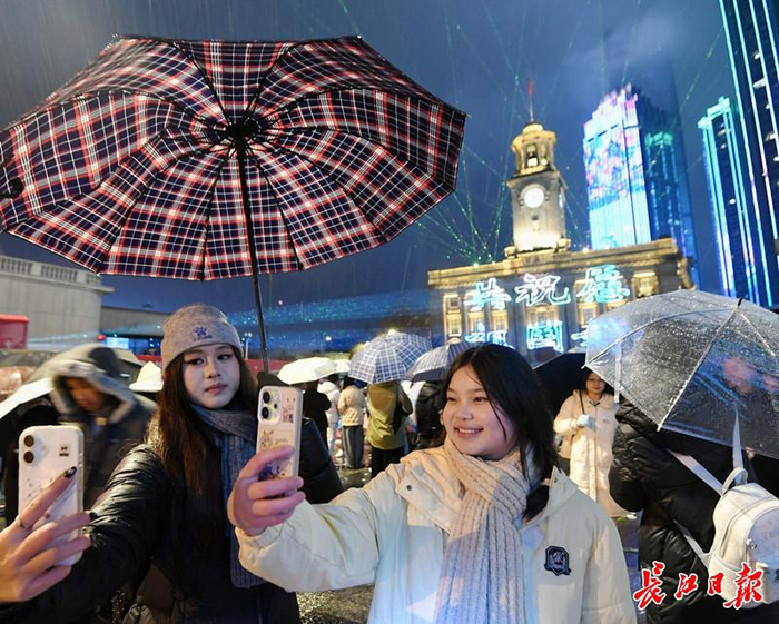 2025年12月31日晚，“你好，2026”江汉关跨年光影秀在江汉关广场举行，年轻人举着手机自拍。 长江日报记者史伟 摄