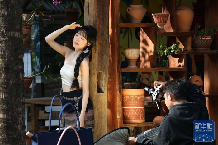 ↑ 1月2日，游客在云南省景洪市曼弄枫街道曼贺纳古寨拍照。新华社发（李云生摄）