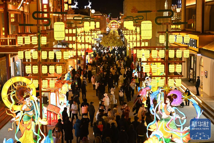 ↑ 1月1日晚，游客在甘肃省敦煌夜市商业街游览选购特色文创产品。新华社发（张晓亮摄）
