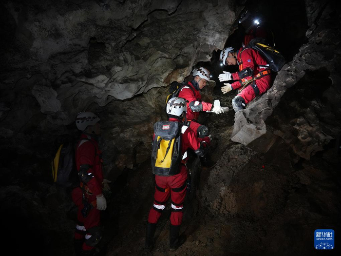 　　2025年12月，航天员在洞穴中进行物品传递协作训练。新华社发