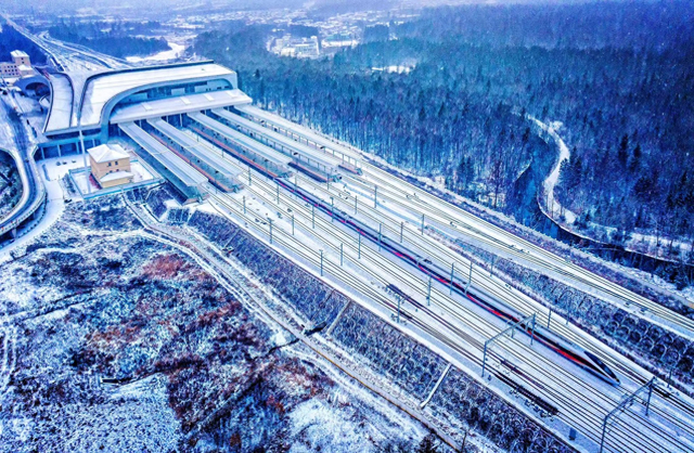 2025年11月27日，智能复兴号动车组驶出大雪纷纷的长白山高铁站。孙立君/摄影