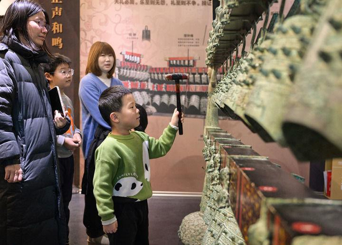 △2026年1月3日，小游客在中国考古博物馆互动展区参加仿古编钟的敲击体验活动。