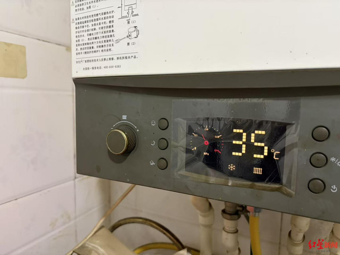 ▲有村民将燃气炉调至低温运行状态 付垚/摄