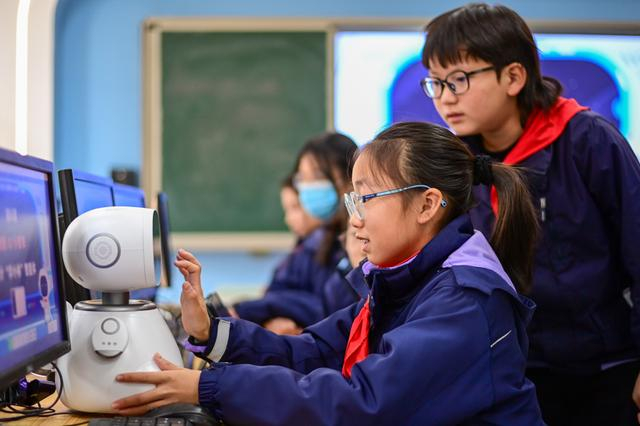 12月5日，杭州市钱塘区学林小学的学生在人工智能通识课上对人工智能机器人进行编程。 新华社记者 江汉 摄