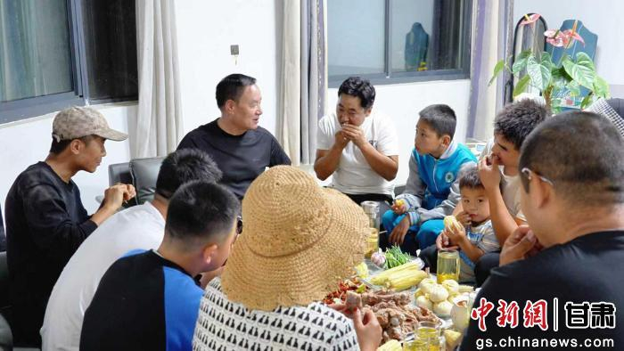   马一四夫（左五）在宿舍与职工沟通。（资料图）临夏县融媒体中心供图 