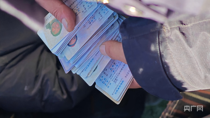 银行工作人员正在清点即将发放补贴的村民证件