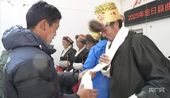 班久岗村党支部书记阿律为村民发分红、戴哈达（定日融媒供图）