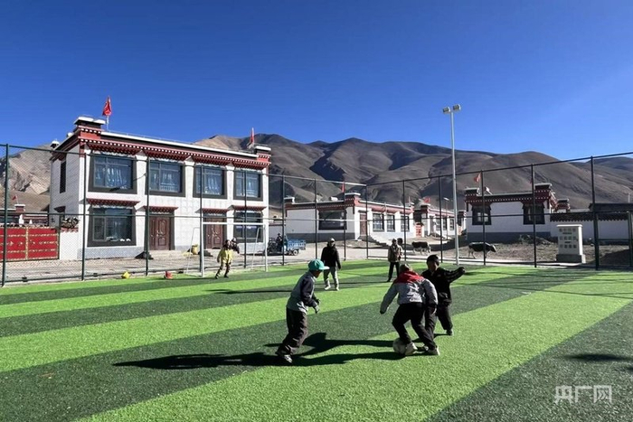 定日县长所乡森嘎村，孩子们在新建的足球场踢球