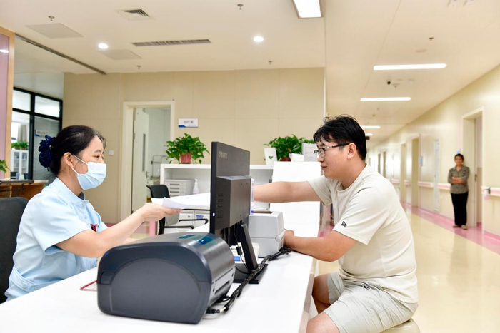 2025年8月21日，在郓城县人民医院产科护士站，工作人员在为产妇家属做诊间医保结算。新华社记者 郭绪雷 摄