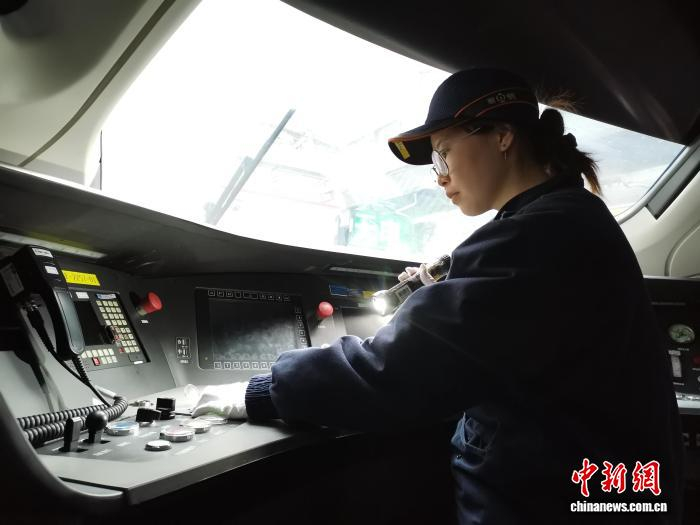 图为作业人员对动车组司机室按钮进行检查。 李各 摄