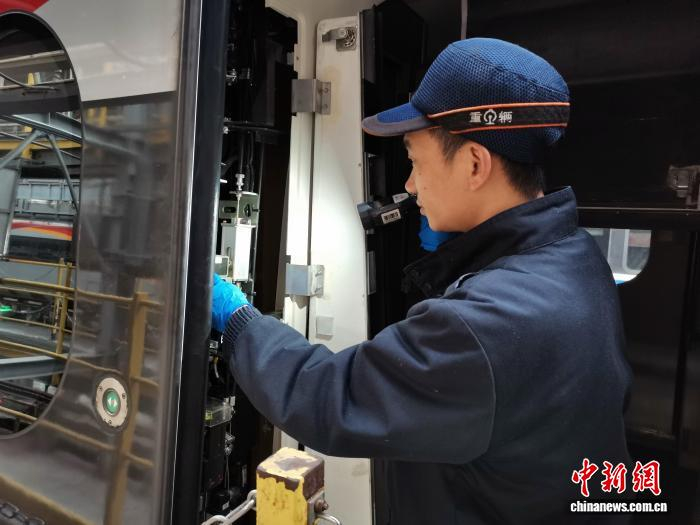 图为作业人员对动车组塞拉门进行检查。 李各 摄