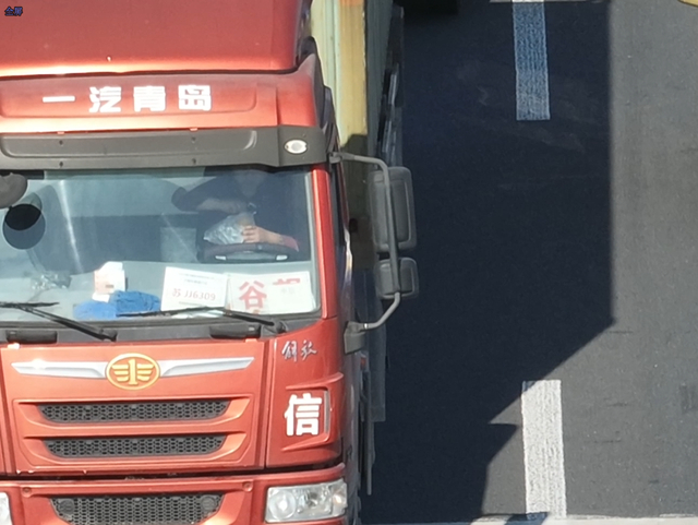 司机一手点手机一手夹烟