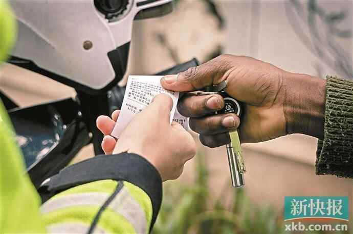 ■广州交警对违法车辆开罚单。