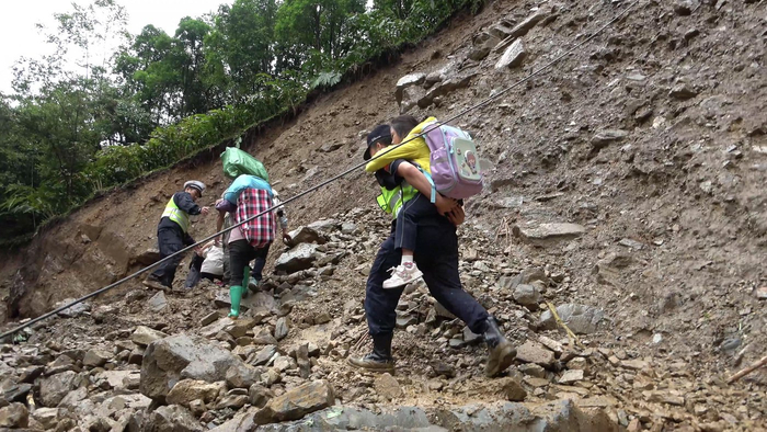 民警背着小女孩通过塌方地段。余润强摄