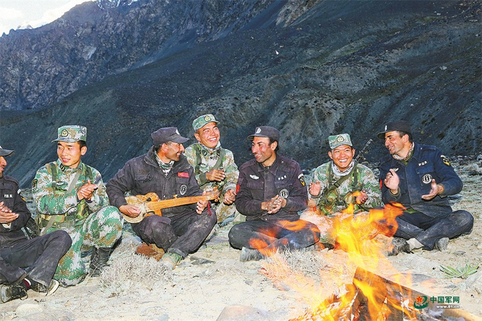 　　官兵与塔吉克族护边员巡逻途中短暂休整（资料图片）。胡 铮摄