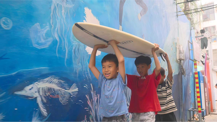 藤海社区本地孩子下海冲浪（央广网记者 陶淦 摄）