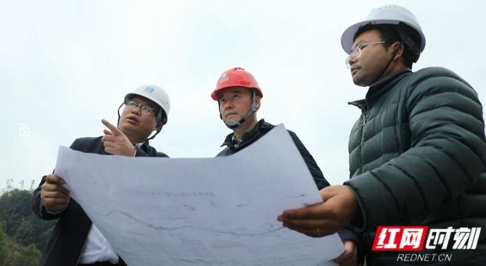 李釗（中）在施工現(xiàn)場與技術(shù)團(tuán)隊(duì)討論方案。