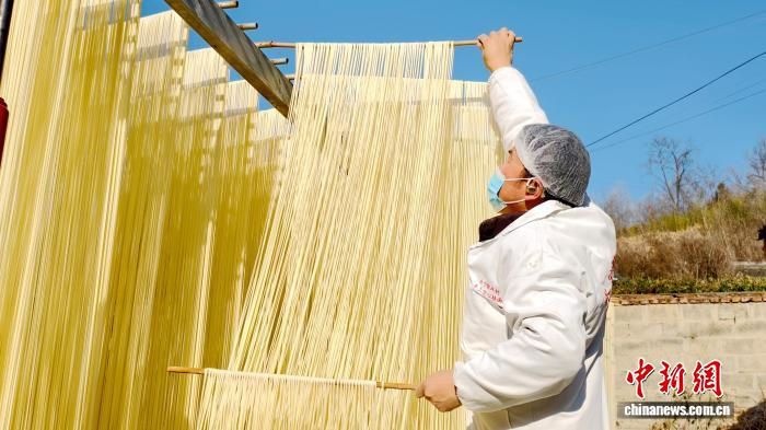 圖為1月初，甘肅隴南市徽縣永寧鎮(zhèn)綠鑫手工空心掛面農(nóng)民專業(yè)合作社內(nèi)，師傅們?cè)诹罆袷止烀?。何?攝