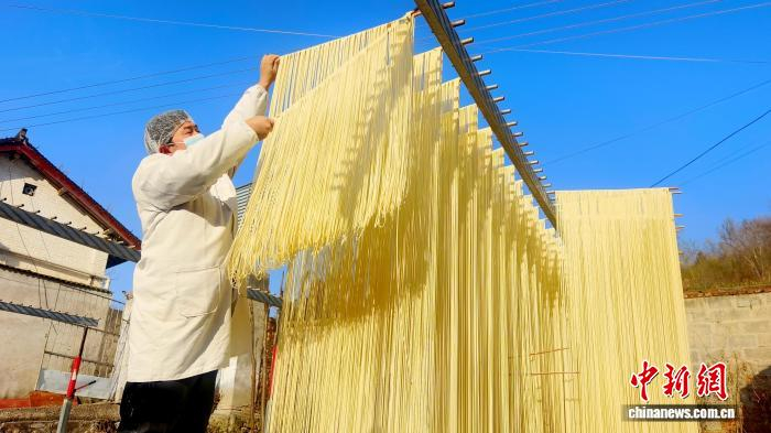 圖為1月初，甘肅隴南市徽縣永寧鎮(zhèn)綠鑫手工空心掛面農(nóng)民專業(yè)合作社內(nèi)，師傅們?cè)诹罆袷止烀妗：畏?攝