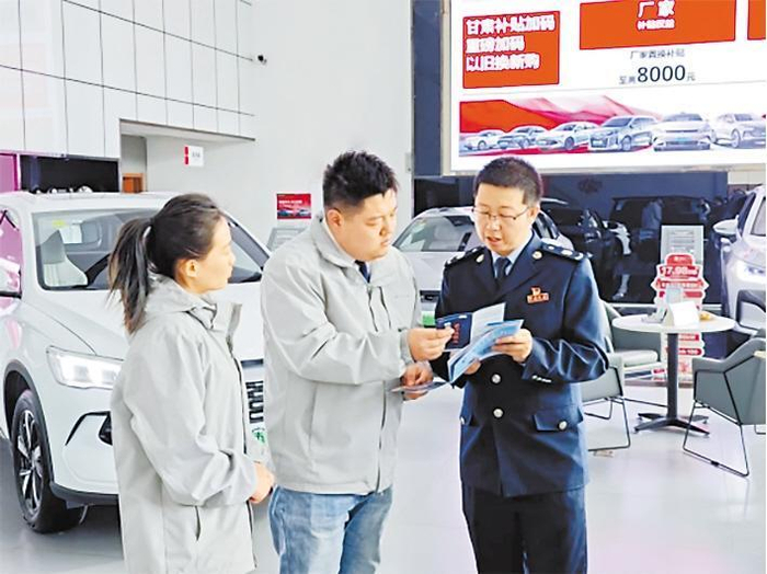     凉州区税务局干部向汽车4S店工作人员宣传车辆购置税政策。甘肃省税务局供图
