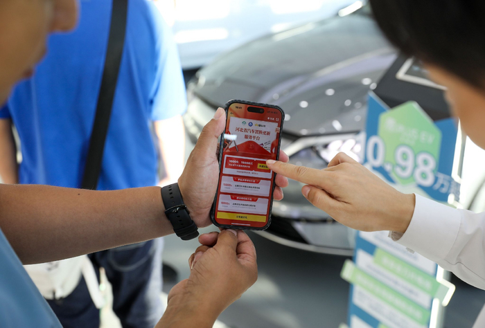 2025年衡水鑫和世家4S店，销售人员帮助顾客申请汽车置换补贴。陈康摄