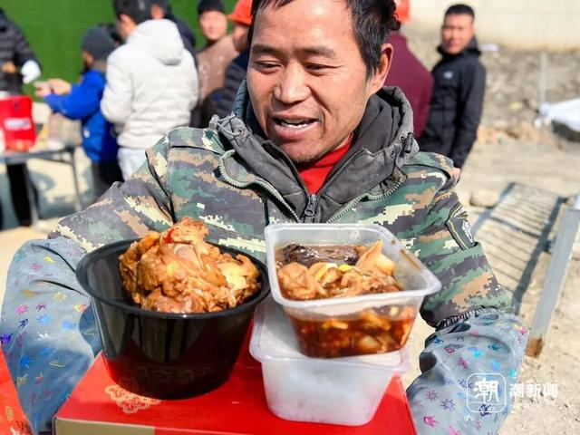 曾信金向大家展示饭菜。谢春晖 摄 