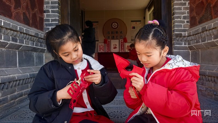 孩子們坐在非遺館門(mén)剪紙（央廣網(wǎng)發(fā) 楊蕊 攝）