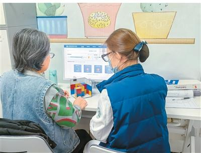 70岁的于奶奶（左）在护士指导下拼三色立方拼图。