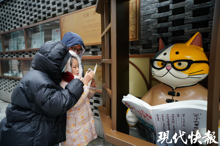 游人紛紛打卡“賣報喵”
