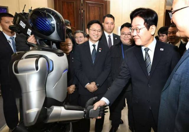 1月7日，中韓創(chuàng)新創(chuàng)業(yè)論壇在上海舉行，韓國(guó)總統(tǒng)李在明與論壇企業(yè)展展區(qū)上的中國(guó)機(jī)器人握手。新華社發(fā)