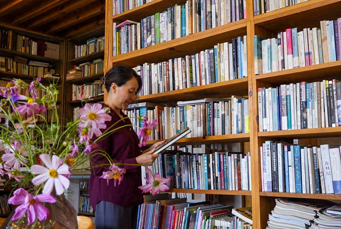 令嘉在自家圖書館里整理圖書。來(lái)源：人民日?qǐng)?bào)客戶端云南頻道