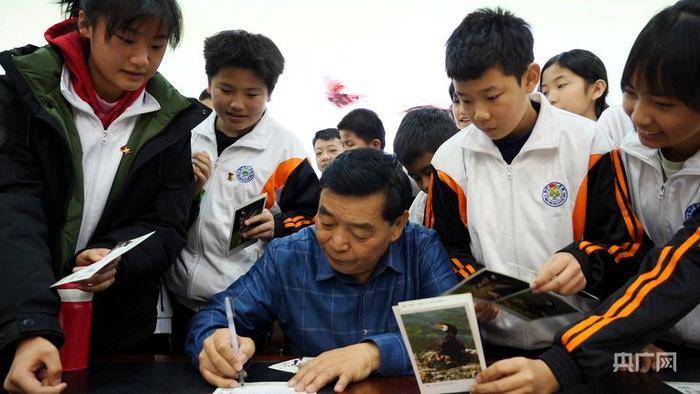 講座結(jié)束后，葛玉修給孩子們題字贈送野生動物畫片（央廣網(wǎng)記者 汪曉青 攝）
