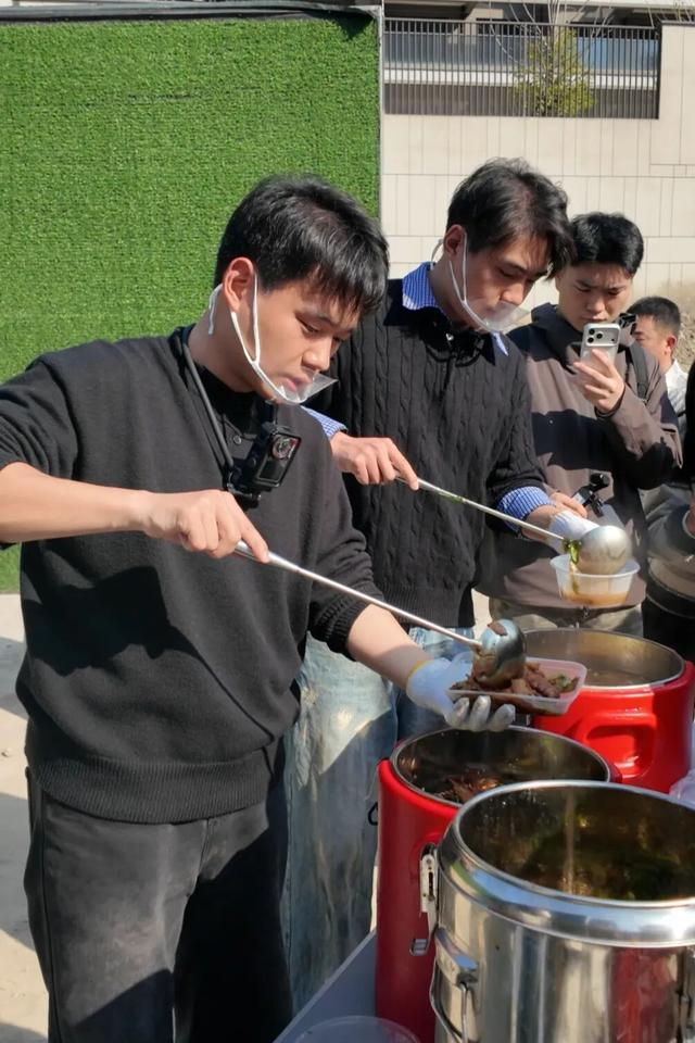 张腾飞为工友打盒饭（央广网记者 俞烨 摄） 