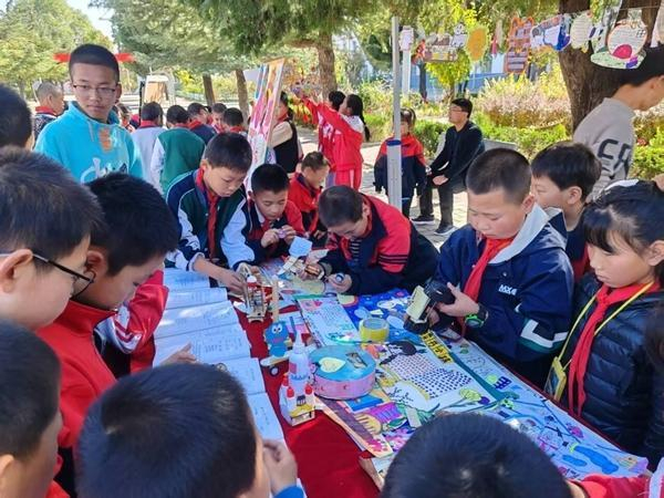 涇川縣紅河鄉(xiāng)九年制學(xué)校讀書(shū)成果展上，學(xué)生參觀、交流各班展出的作品。涇川縣教育供圖