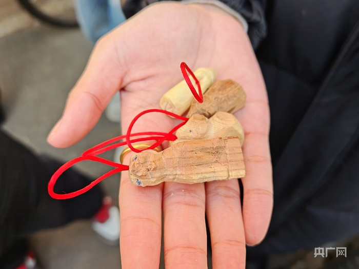 游客展示精心挑選的木雕（央廣網(wǎng)記者 龐婷 攝）