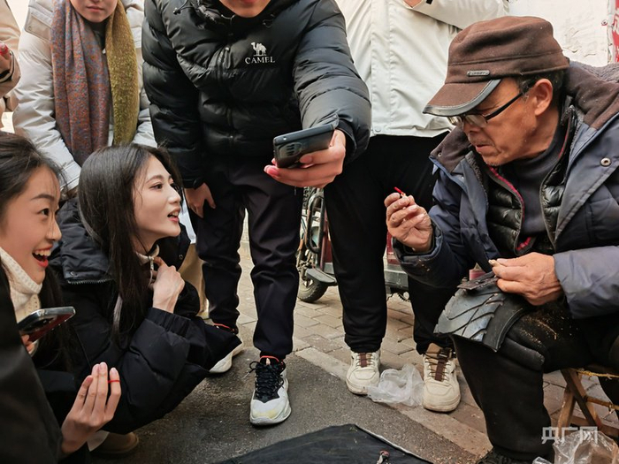 大爺給顧客解答木雕品類（央廣網(wǎng)記者 龐婷 攝）